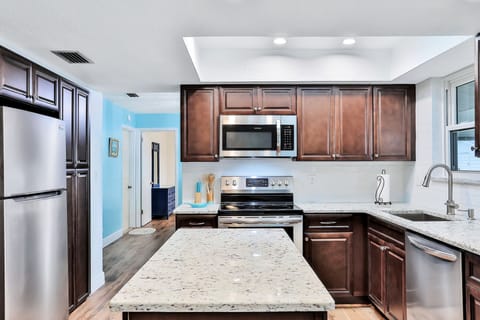 Make the most of your beach stay in this bright, spacious kitchen with a central island, modern appliances, and ample prep space—ideal for easy meals, morning coffee, and relaxed coastal living.
