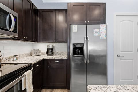 Modern kitchen with stainless steel appliances, granite countertops, and ample cabinetry. Perfect for preparing meals and snacks to enjoy together during your relaxing beach stay vacation.