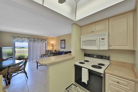 Open-concept kitchen overlooking the living area with coastal charm and modern appliances. Enjoy easy meal prep and relaxing together during your beach stay, just steps from fresh ocean air.