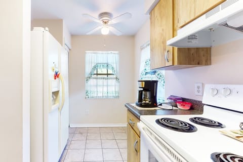 Bright coastal-inspired kitchen with plenty of natural light—perfect for prepping snacks and meals during your relaxing beach stay. Includes full appliances and a comfy dining nook.