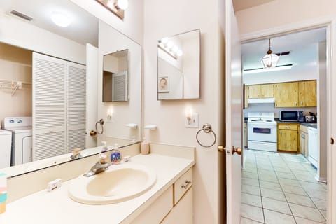 Handy bathroom with direct access to the laundry area—perfect for refreshing after sandy beach days. Bright, clean, and designed for easy vacation living.
