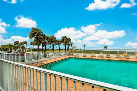 Enjoy your beach stay by the oceanfront pool surrounded by palm trees and lounge chairs. Relax, soak up the sun, and take in refreshing coastal breezes just steps from the sandy shoreline.