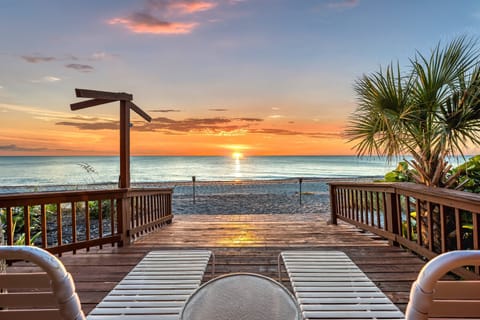 Relax on the sun-warmed chaise lounge as the sky ignites in gold and coral, waves gently lapping below.