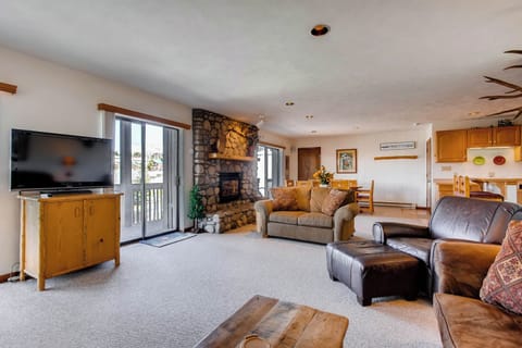 Experience the warmth of cozy alpine design in this inviting living space, complete with a stone fireplace for chilly nights.
