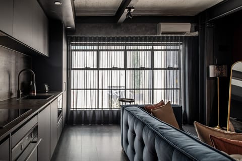 Sleek open-plan living with a modern kitchenette, plush seating and floor-to-ceiling windows that fill the space with natural light