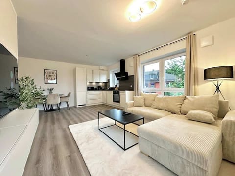 Gemütliches Wohnzimmer mit 50-Zoll-Smart-TV, gemütlicher Essecke und flauschigem Teppich.