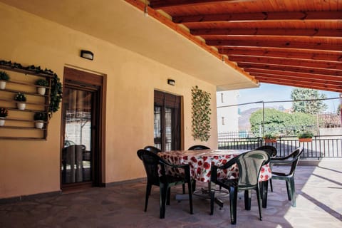 Tranquil covered terrace with an outdoor dining table, offering a lovely spot for morning coffee or open-air meals.