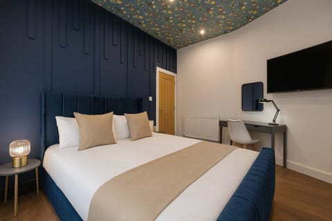 Large King Size Bed with Crisp Linen and work desk or for getting ready with mirror and desk lamp