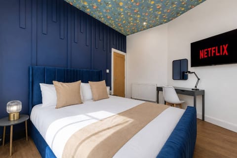 Large King Size Bed with Crisp Linen and work desk or for getting ready with mirror and desk lamp