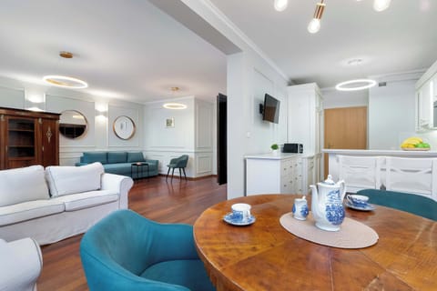 A stylish living area with a round wooden dining table and comfortable seating, perfect for meals and relaxation.
