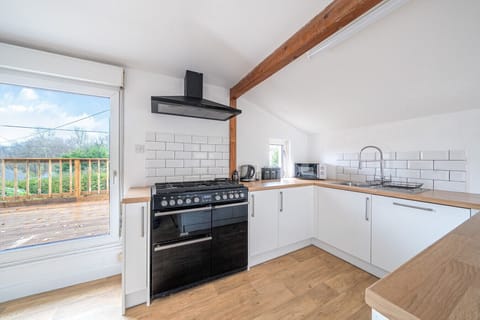 Stylish kitchen with black appliances and wooden worktops.