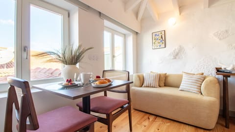 Sun-filled lounge with large windows and charming street views — ideal for both work and relaxation. #CityViews #RemoteWorkReady #PortugalStay”