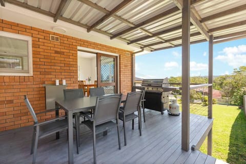 The private deck features an outdoor dining table and a gas BBQ, creating an easygoing setting for relaxed meals in the coastal air.
