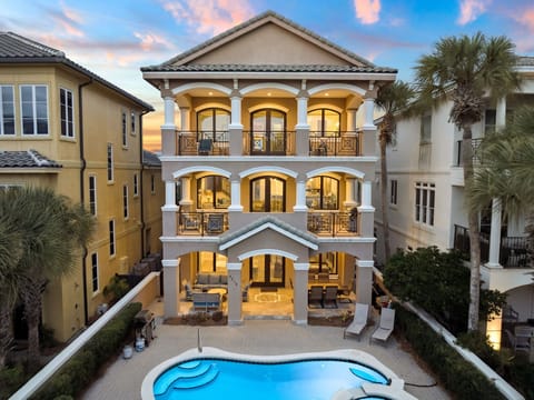 Luxurious three-story beachfront estate with private pool and elegant architecture in an upscale coastal neighborhood.