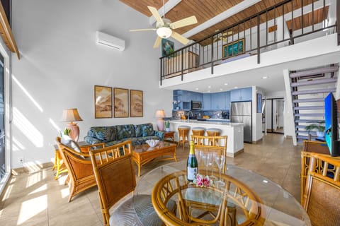 Open flow between the living area and the fully equipped kitchen. Plus, you can see the cool loft area upstairs overlooking everything—it's a great extra hangout space!