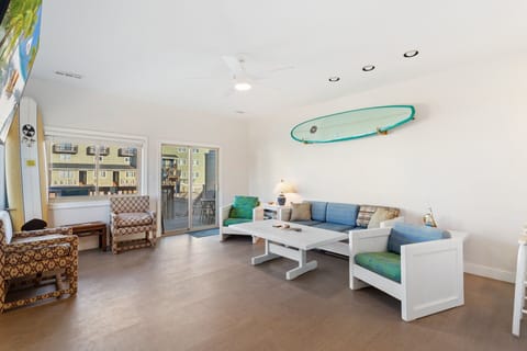 Main Living Area: Bright and welcoming living space with coastal décor and deck access.