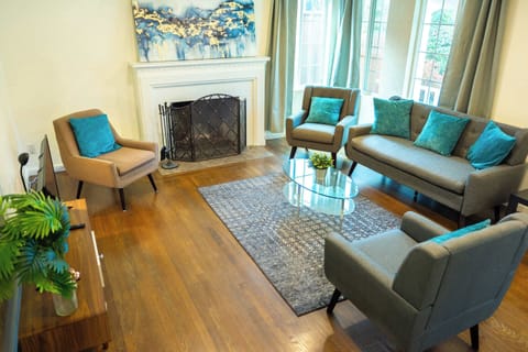 Relax in this inviting living room where cozy seating, warm wood floors, and a charming fireplace create the perfect setting for comfortable gatherings and quiet evenings in