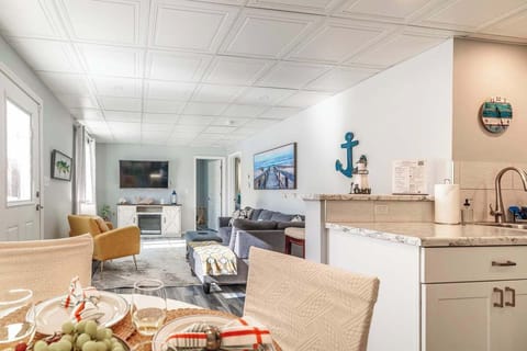 View from the dining table into the cozy living room, with the kitchen’s one-seat counter in sight. The open layout keeps everyone connected—perfect for chatting, snacking, and relaxing together.