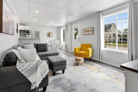 Comfortable living room with couch and chair that is open to the kitchen and dining area. Features a smart tv.