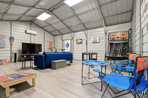 Fully air-conditioned game room with TV, games, and comfy lounge seating.