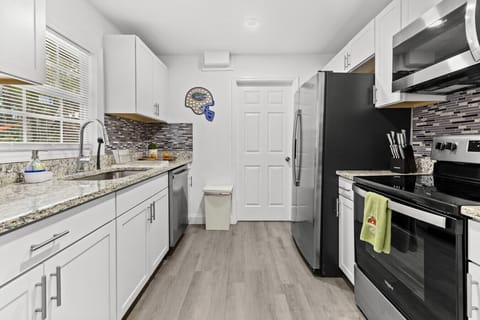Open, modern kitchen with granite details and stainless accents throughout.
