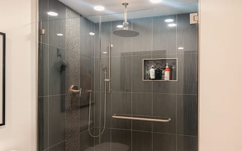 Full shared bathroom with spacious walk-in shower and modern tile, used only by guests in The Gold Room and the on-site hosts at Garden of Manors.