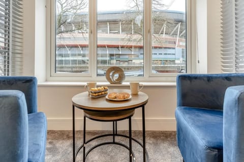 tub chairs and table in king bedroom with views over the Principality Stadium  at Hafan y Ddinas Cardiff Apartment 2