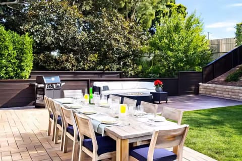Private backyard oasis with lush greenery and a spacious dining table for 10. Perfect for group gatherings, outdoor entertaining, and relaxing alfresco meals surrounded by nature.