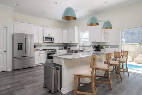 "Perch at the stylish kitchen bar on rattan stools under sea‑glass pendants. It’s the perfect spot for morning coffee or evening drinks before heading out. - The Coquina - St. Augustine, FL"