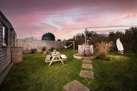 Garden with wood-fired hot tub and seating to the rear of the lodge