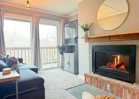 Spacious living area with Roku TV, and sliding doors to the balcony.     Note: The fireplace is not operational due to an issue with the chimney