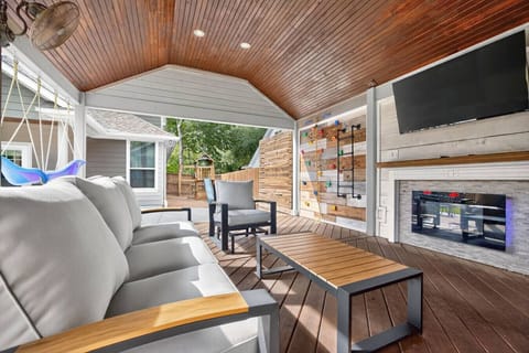 Beautiful patio with plush seating, TV, and a cozy fireplace, along with full views of the swing and climbing wall for built-in family fun.