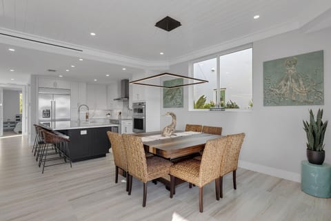 The inviting dining area features a stylish table with seating for eight, complemented by an additional four seats at the kitchen island—perfect for family meals and casual gatherings.