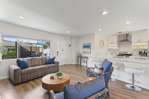 Bright open living area w/ cozy sofa seating & large windows bringing in natural light