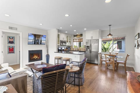 Bright open living & dining area w/ cozy fireplace, large windows & seamless flow into the kitchen