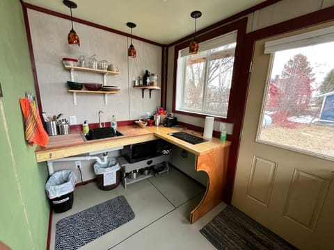 Fully stocked kitchen with fridge, microwave, stovetop, kettle and coffee.
