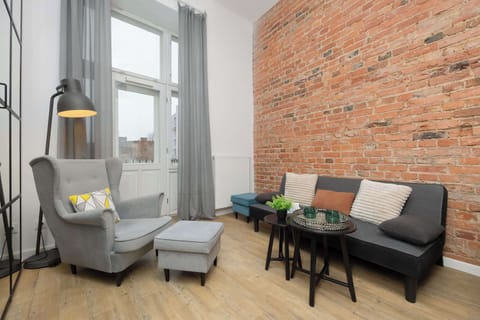 Living area with comfortable seating and exposed brick wall.