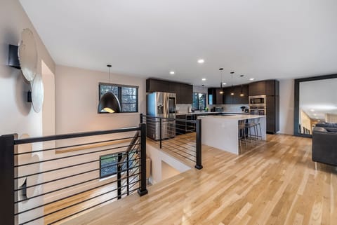 Your open-concept kitchen flows seamlessly with hardwood floors and sleek modern design, perfect for cooking and entertaining.