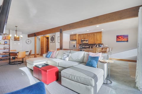 Relax in your spacious open-plan retreat where rustic wood beams meet modern comfort. Sink into the plush sectional sofa while enjoying mountain views, then whip up meals in your fully-equipped kitchen with warm wood cabinets.