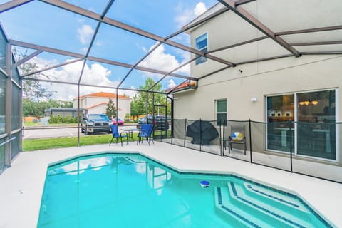 Step outside to your private oasis with a sparkling pool under a screened enclosure. Relax on the cool, white deck, surrounded by lush greenery and an inviting patio, perfect for unwinding after your day of adventure.