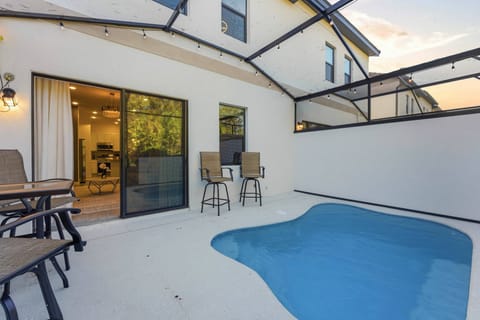 Step outside to your private oasis, where a sparkling pool awaits amid a sleek, enclosed patio. Enjoy casual seating at the bar-height chairs, perfect for sipping drinks while soaking up the sun and the peaceful ambiance.