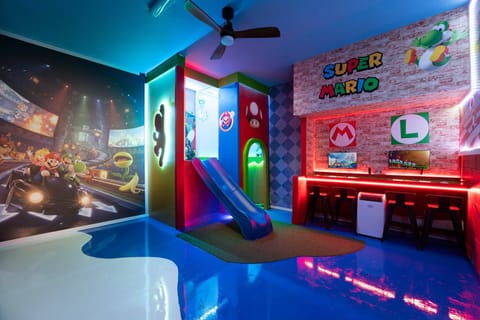 Welcome to a vibrant playroom with a colorful slide and a stunning mural inspired by video games. Bright LED lights enhance the playful atmosphere, making it the perfect spot for kids and families to enjoy together.