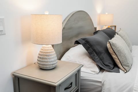 Soft bedside lighting and cozy textures create a calm, restful atmosphere.