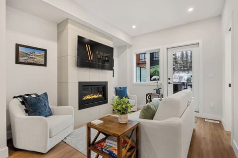 Living room with a gas-lit fireplace, Smart TV, board games and access to the first balcony with a private hot tub.