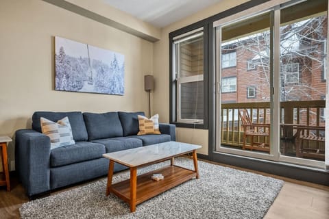 Living area/studio space with a gas-lit fireplace, dedicated workstation, access to the private balcony and a pull-out sleeper sofa (all linens provided.)