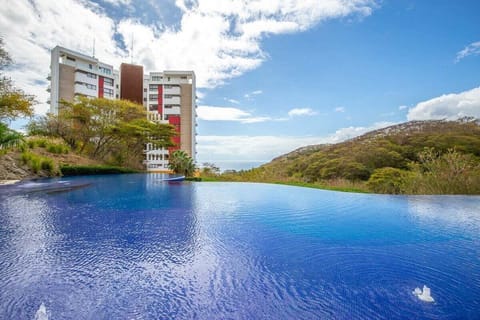 A wide-angle shot of the bright blue infinity pool where the water appears to blend into the sky.