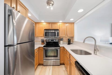 Sleek kitchen corridor w/ stainless appliances & efficient layout.