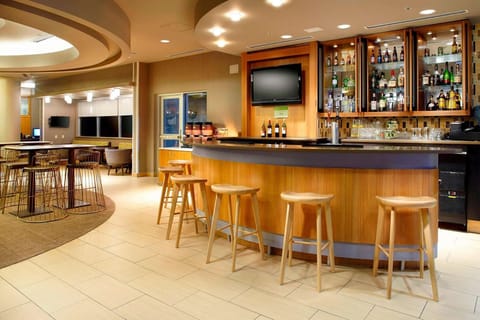 Warm bar area with high stools and bottles on display