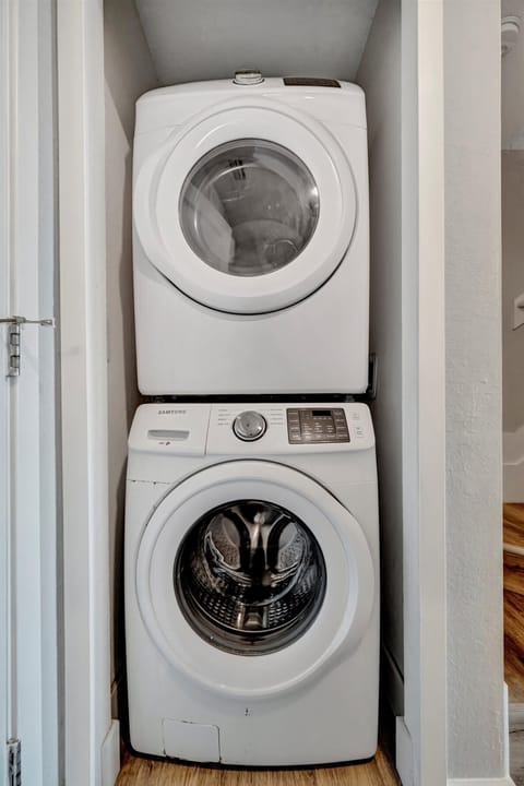 A modern, compact laundry setup—washer and dryer stacked neatly in a dedicated closet, ready whenever you need them.