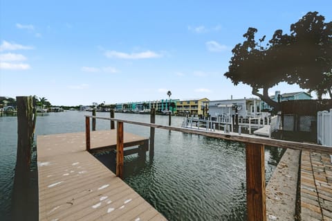 A private dock extends into calm waterfront waters, offering direct access for boating adventures and peaceful moments by the bay.